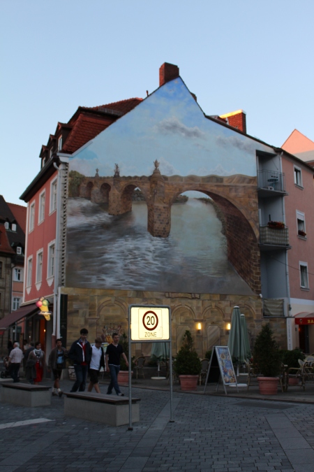 Ob Bilder, Schriftzüge oder Zeichen...Straßenkunst wie Graffiti hat bei vielen einen negativen Charakter. Dass aber solche Kunst auf Häusern auch wunderschön und sogar passend zu einer Altstadt wie Bamberg sein kann, sieht man auf diesem Bild.
